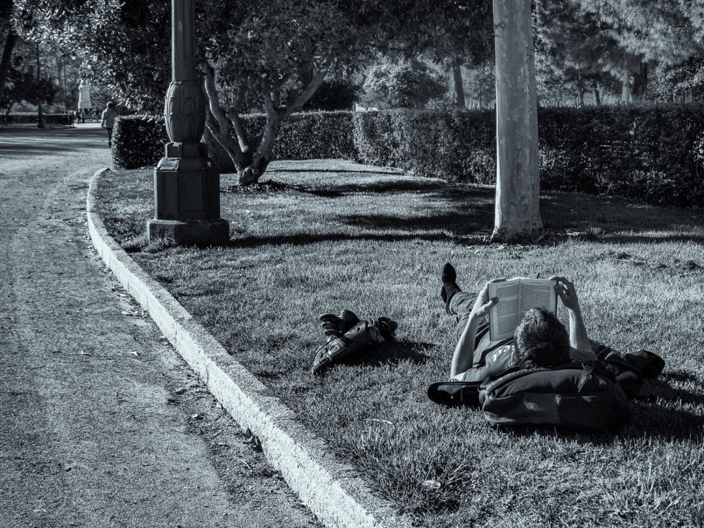 Chico leyendo en un parque. Niko López.