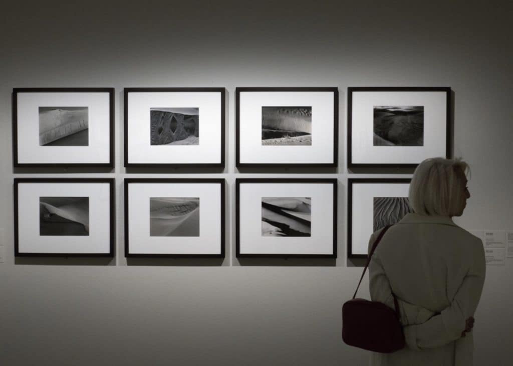 Una visitante frente a fotografías expuestas de Edward Weston