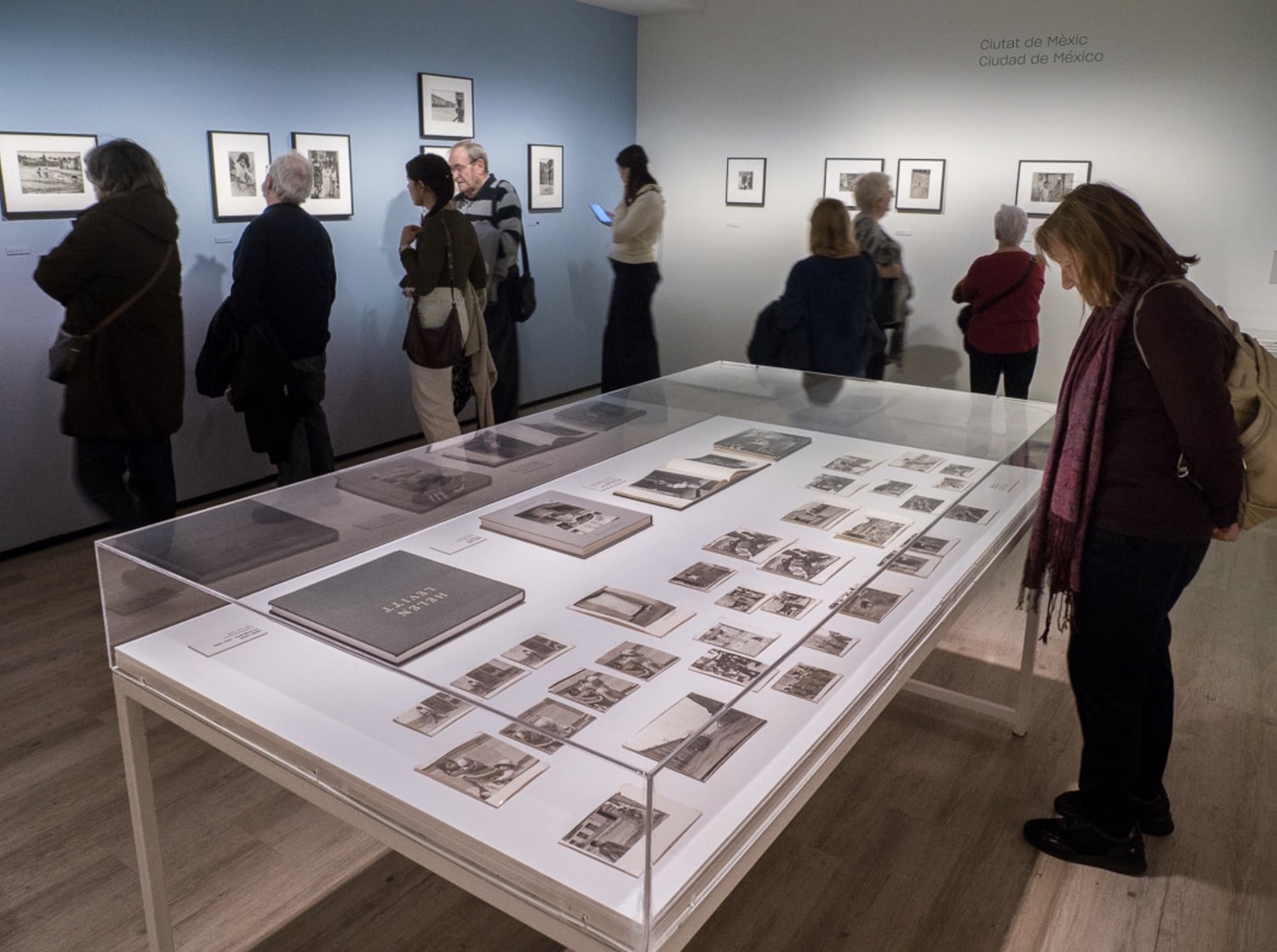 Asistentes junto a una vitrina en la exposición de Helen Levitt en Barcelona.
