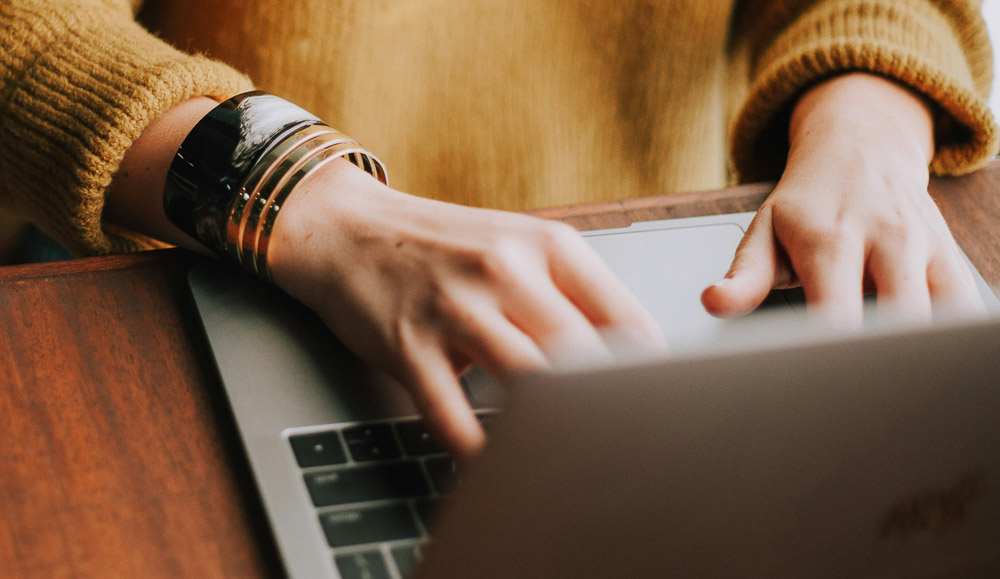 Un empleado escribiendo en un teclado un mensaje de asistencia a un cliente