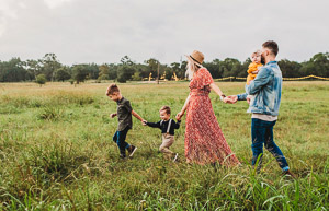 Couple with three children in a meadow.